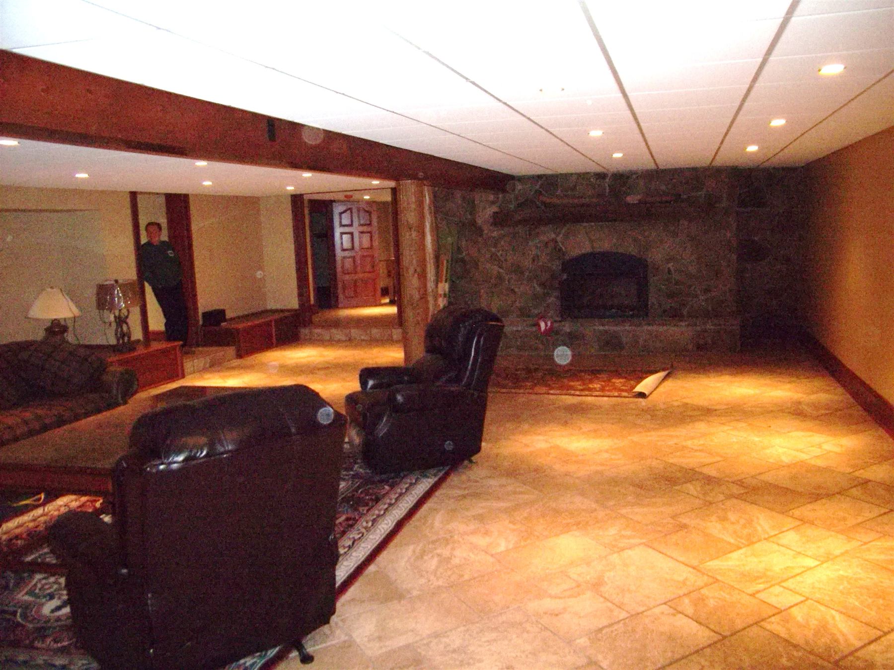 Finished basement with stone fireplace and seating area