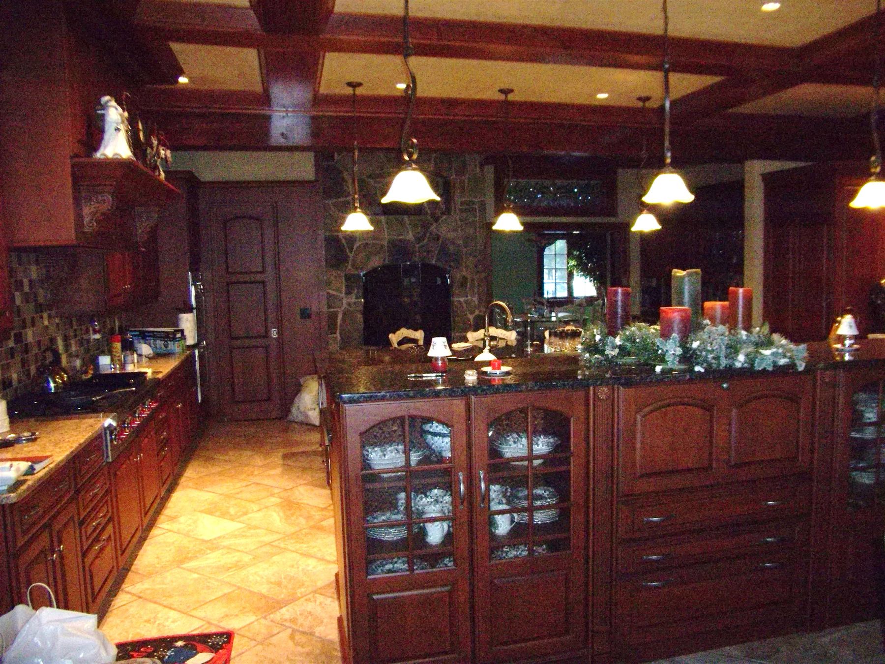 Custom remodeled kitchen with dark wood cabinetry and granite island